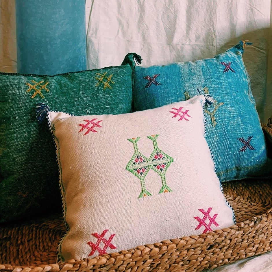 three square pillows in a basket